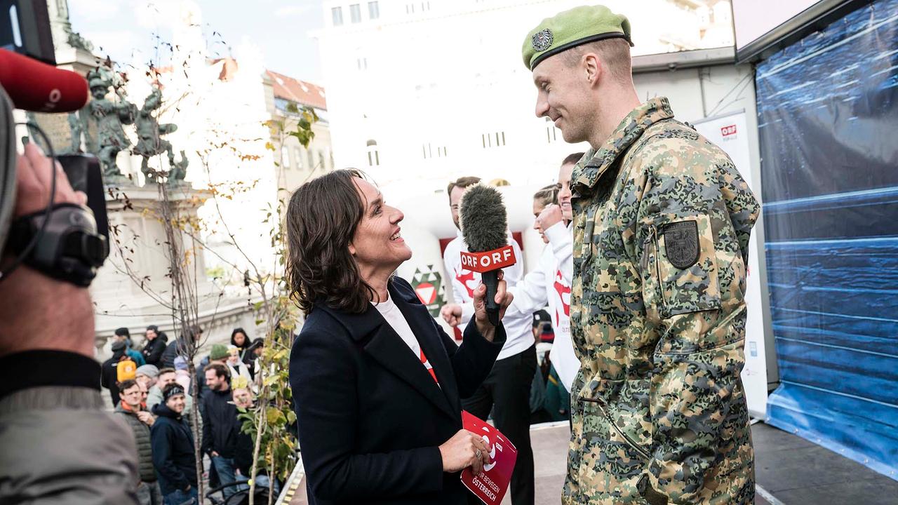 © ORF/Thomas Jantzen Eva Pölzl interviewt einen Bundesheer-Soldaten auf einer Bühne.